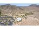 Aerial view featuring desert landscape, mountain views, and a community building with ample parking at 851 E Village Circle N Dr, Phoenix, AZ 85022