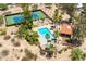 Aerial view of a luxury pool and cabana near a blue and green tennis court surrounded by desert landscaping at 851 E Village Circle N Dr, Phoenix, AZ 85022