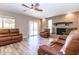 Comfortable living room features a brick fireplace, ceiling fan and sliding glass doors to outdoor patio at 851 E Village Circle N Dr, Phoenix, AZ 85022