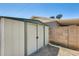 Durable storage shed located in the backyard against a brick wall for convenience at 856 N Evergreen St, Chandler, AZ 85225