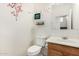 Cozy half bathroom featuring a decorative flower wall decal and wooden vanity at 9133 W Virginia Ave, Phoenix, AZ 85037