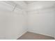 Walk-in closet offering ample storage space with built-in shelves and carpet flooring at 9133 W Virginia Ave, Phoenix, AZ 85037