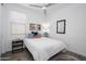 The bedroom offers a calming retreat with its neutral colors, wood-look floors, and ceiling fan at 9238 W Roma Ave, Phoenix, AZ 85037