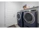 This laundry room features a pair of navy-colored washer and dryer units and extra storage space at 9238 W Roma Ave, Phoenix, AZ 85037