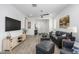 Open-concept living room with wood tile floors, modern decor, and plenty of light at 9238 W Roma Ave, Phoenix, AZ 85037