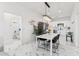 Bright dining area features marble floors, a modern chandelier, and a view into the home's contemporary kitchen at 9471 W Magnum Dr, Arizona City, AZ 85123