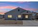 Charming home showcasing warm interior lighting and beautiful sunset hues in the sky above at 9471 W Magnum Dr, Arizona City, AZ 85123
