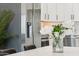 Bright kitchen showcasing stainless steel appliances, sleek white cabinetry, and a view into the dining area at 9471 W Magnum Dr, Arizona City, AZ 85123