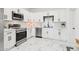 Modern kitchen features white cabinets, stainless steel appliances, marble floors, and white marbled countertops at 9471 W Magnum Dr, Arizona City, AZ 85123