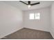Comfortable bedroom featuring a ceiling fan, neutral carpeting, and a window with a view at 1051 E Millett Ave, Mesa, AZ 85204