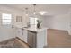 Stylish kitchen island with stainless steel dishwasher, white cabinets and countertops, and modern fixtures at 1051 E Millett Ave, Mesa, AZ 85204