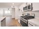 Well-equipped kitchen featuring stainless steel appliances, white cabinets, and an open layout to the living area at 1051 E Millett Ave, Mesa, AZ 85204