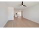 Open-concept living area with wood-look floors, a modern ceiling fan, and a view into the kitchen at 1051 E Millett Ave, Mesa, AZ 85204
