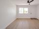 Bright living room featuring wood-look flooring, a modern ceiling fan, and a light-filled window at 1051 E Millett Ave, Mesa, AZ 85204