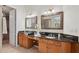 Bathroom featuring double sinks with granite countertops and decorative mirrors at 11299 E Greythorn Dr, Scottsdale, AZ 85262
