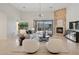 Living room with a stone fireplace, neutral furniture, and a large sliding glass door at 11299 E Greythorn Dr, Scottsdale, AZ 85262