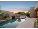 Scenic backyard pool with rock accents, lush greenery, and lounge seating for relaxation at 11299 E Greythorn Dr, Scottsdale, AZ 85262