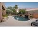 Inviting backyard pool with a rock waterfall feature surrounded by lush landscaping at 11299 E Greythorn Dr, Scottsdale, AZ 85262