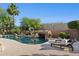 Beautiful pool with rock waterfall feature and well maintained landscaping and lounge chairs for relaxing in the sun at 11299 E Greythorn Dr, Scottsdale, AZ 85262