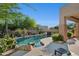 Inviting pool area featuring lush desert landscaping, boulder accents, and a relaxing, private backyard retreat at 11299 E Greythorn Dr, Scottsdale, AZ 85262