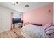 Cozy bedroom featuring a twin bed, desk with TV, and wood-look floors at 11383 W Pima St, Avondale, AZ 85323