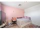 Bright bedroom featuring a twin bed, pink walls and decorative accents at 11383 W Pima St, Avondale, AZ 85323