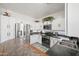 Bright kitchen featuring stainless steel appliances, white cabinets, and black countertops, creating a modern culinary space at 11383 W Pima St, Avondale, AZ 85323