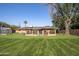 Spacious backyard with well-manicured lawn, established trees, greenhouse, and a cozy gazebo at 1158 N Barkley St, Mesa, AZ 85203