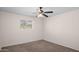 A carpeted bedroom has a window and ceiling fan with a light fixture at 1158 N Barkley St, Mesa, AZ 85203