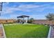 Large backyard featuring a custom pergola, gas fireplace, and green lawn at 1160 E Peach Tree Dr, Chandler, AZ 85249