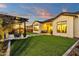 Expansive backyard showcasing artificial turf, modern pavers, fire pit, pergola, and elegant home exterior at 1160 E Peach Tree Dr, Chandler, AZ 85249