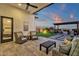 Inviting backyard featuring a covered patio, modern pavers, artificial turf, fire pit, and comfortable lounge furniture at 1160 E Peach Tree Dr, Chandler, AZ 85249