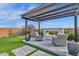 Pergola-covered outdoor fireplace area with manicured lawn and seating at 1160 E Peach Tree Dr, Chandler, AZ 85249