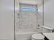 Well-lit bathroom with a marble-tiled shower over tub, a small window, and bright, white fixtures at 1225 N 159Th Ln, Goodyear, AZ 85338