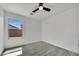 Bright bedroom with a ceiling fan, wood-look flooring, and a view of the backyard through a large window at 1225 N 159Th Ln, Goodyear, AZ 85338