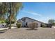 Spacious single-story home featuring desert landscaping with gravel and various trees under a blue sky at 1225 N 159Th Ln, Goodyear, AZ 85338