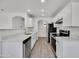 Well-lit kitchen features stainless steel appliances, white cabinets, and stone countertops at 1225 N 159Th Ln, Goodyear, AZ 85338
