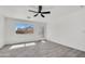 Bright, airy living room with gray wood-look tile flooring, white walls, ceiling fan, and natural light at 1225 N 159Th Ln, Goodyear, AZ 85338