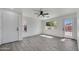 Spacious living room with gray wood-look tile flooring, white walls, doors, and natural light at 1225 N 159Th Ln, Goodyear, AZ 85338