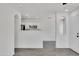 A modern space with white walls and wood-look flooring, leading to an open kitchen area at 1225 N 159Th Ln, Goodyear, AZ 85338