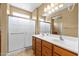 Modern bathroom with double sink vanity, mirrored wall, and enclosed glass shower at 12945 W Yellow Bird Ln, Peoria, AZ 85383