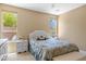 Bright bedroom with light walls, two windows, and a floral patterned queen-sized bed at 12945 W Yellow Bird Ln, Peoria, AZ 85383