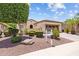 Well-maintained home showcasing desert landscaping with verdant shrubs, mature trees, and an attached two-car garage at 12945 W Yellow Bird Ln, Peoria, AZ 85383