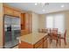 Bright kitchen boasts stainless steel refrigerator, granite island, and adjacent dining area at 12945 W Yellow Bird Ln, Peoria, AZ 85383