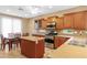 Eat-in kitchen featuring wood cabinets, stainless steel appliances, an island, and breakfast nook with dining table at 12945 W Yellow Bird Ln, Peoria, AZ 85383