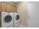 Functional laundry room equipped with a washer, dryer, and overhead cabinets at 12945 W Yellow Bird Ln, Peoria, AZ 85383