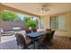 Covered patio with dining table and chairs, fan, and outdoor seating area at 12945 W Yellow Bird Ln, Peoria, AZ 85383