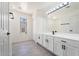 Bathroom with white cabinetry, quartz countertops, black hardware, wood-look tile floors, and a large mirror at 1510 W Fillmore St, Phoenix, AZ 85007