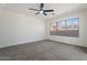 Spacious bedroom with a ceiling fan, neutral carpet, and a large window with plenty of natural light at 1510 W Fillmore St, Phoenix, AZ 85007
