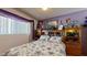 Comfortable bedroom featuring floral bedding, a mirrored headboard, and display shelves showcasing a variety of decor and photos at 1710 W 13Th Ave, Apache Junction, AZ 85120
